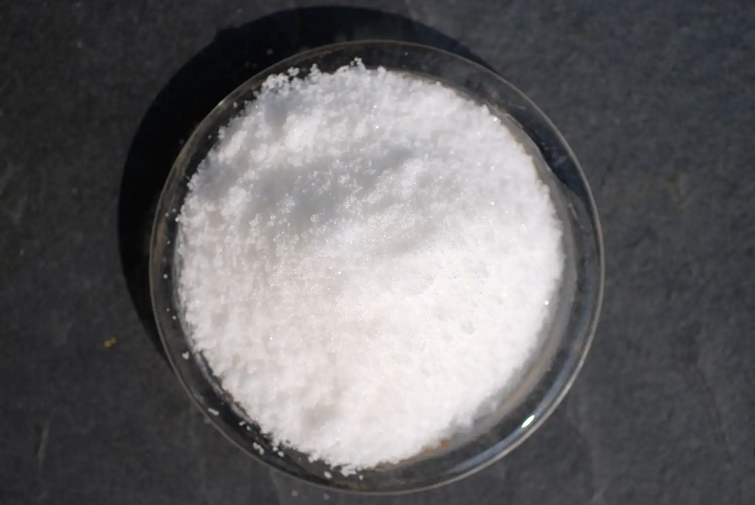 Acetil-L-Carnitina en polvo - 500 g Creatina monohidratada blanca en un tazón transparente, 500 g, vista desde arriba.