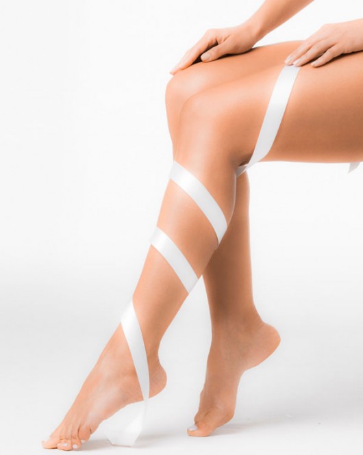 Cinta blanca envuelta alrededor de una pierna femenina, vista lateral, piel suave.