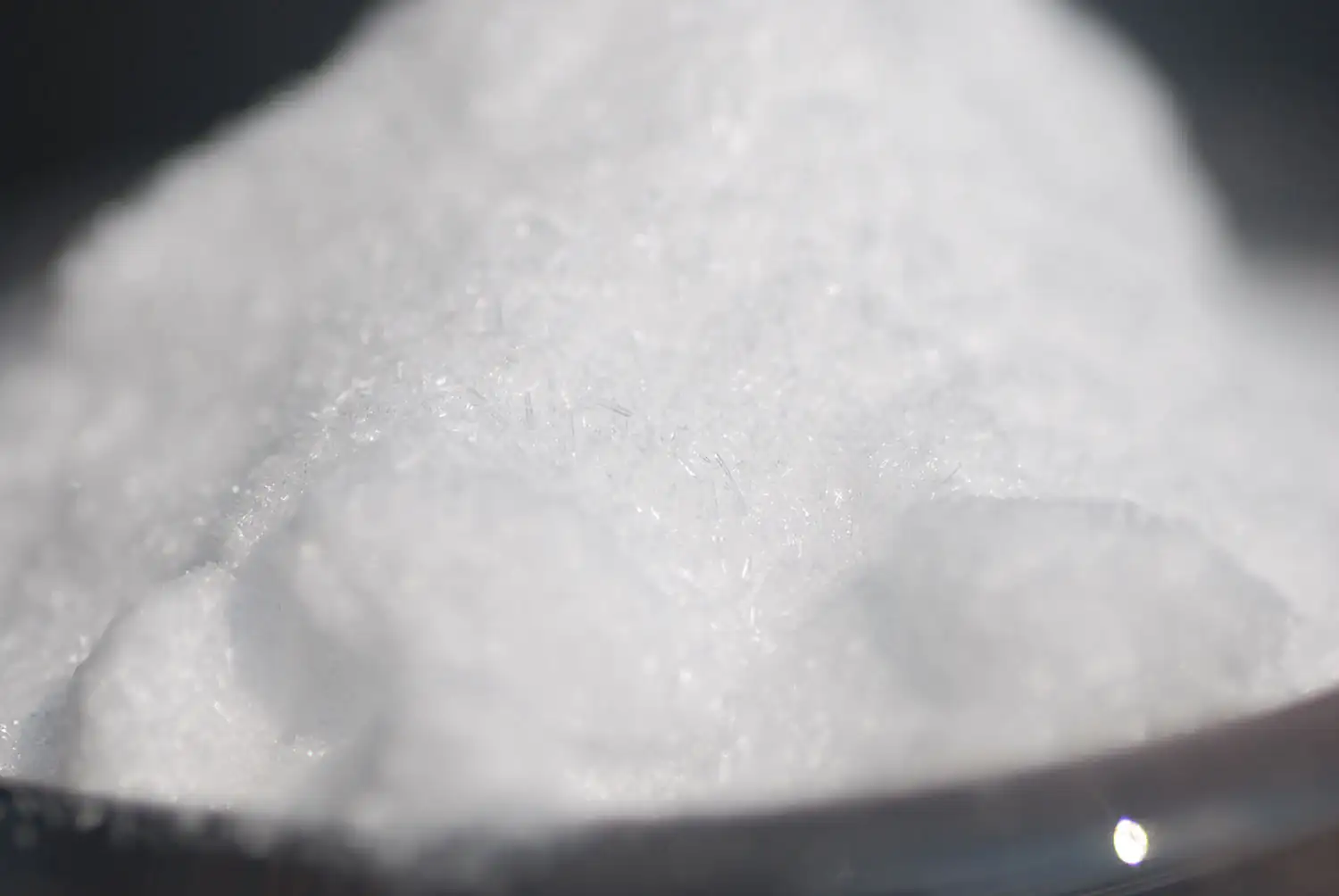 Polvo de L-Taurina, blanco y fino en un cuenco, toma cercana.