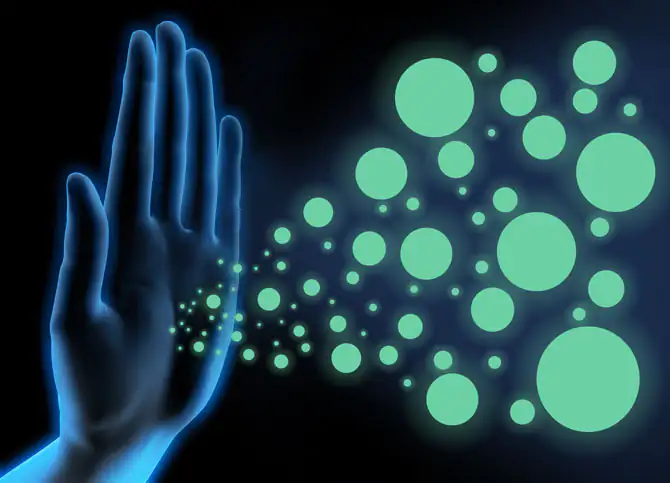 Mano y virus - Prevención y defensa del sistema inmunológico Representación gráfica de una mano de la que emergen partículas verdes y círculos, sobre fondo negro.